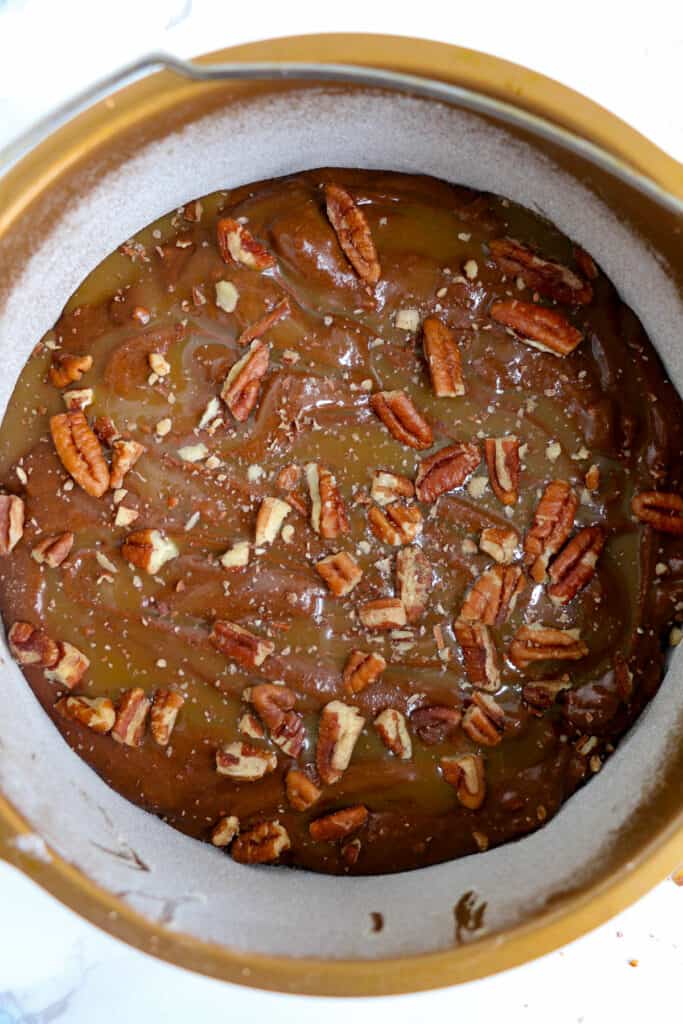 overhead shot of the brownie batter in the baking pan with pecans sprinkled over the top.