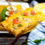 Close up shot of two air fryer chicken enchiladas being lifted with a spatula.