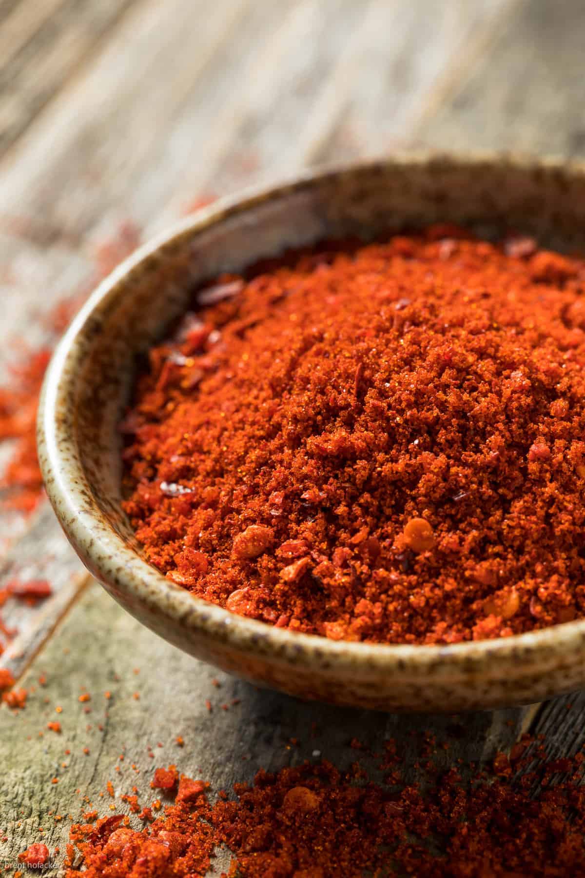 Low angle shot of a bowl of finely ground gochugaru red chili pepper powder.