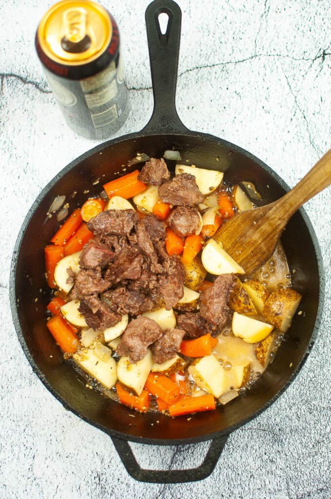 beef, potatoes, carrots, and onions in the cast-iron skillet.