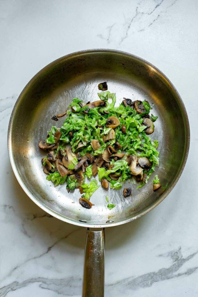 Mushrooms and spinach in a skillet.