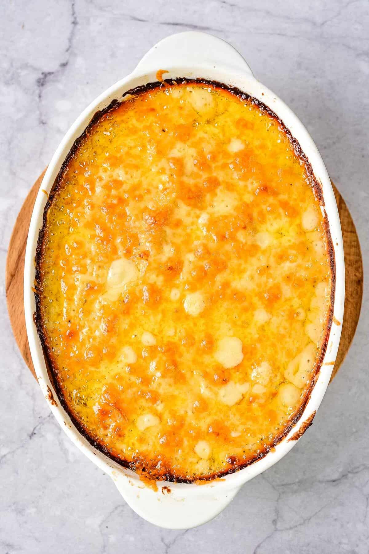 Cheesy potato casserole in a white dish.