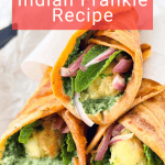 Three Indian Frankie wraps filled with potatoes, green sauce, red onions, and herbs are displayed on a plate with a red banner reading "Indian Frankie Recipe.