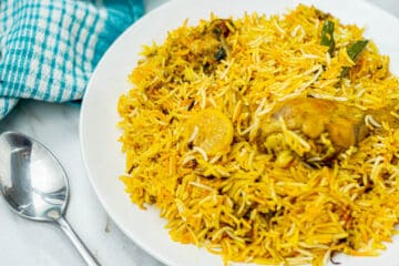 chicken biryani on a plate with a blue and white napkin.