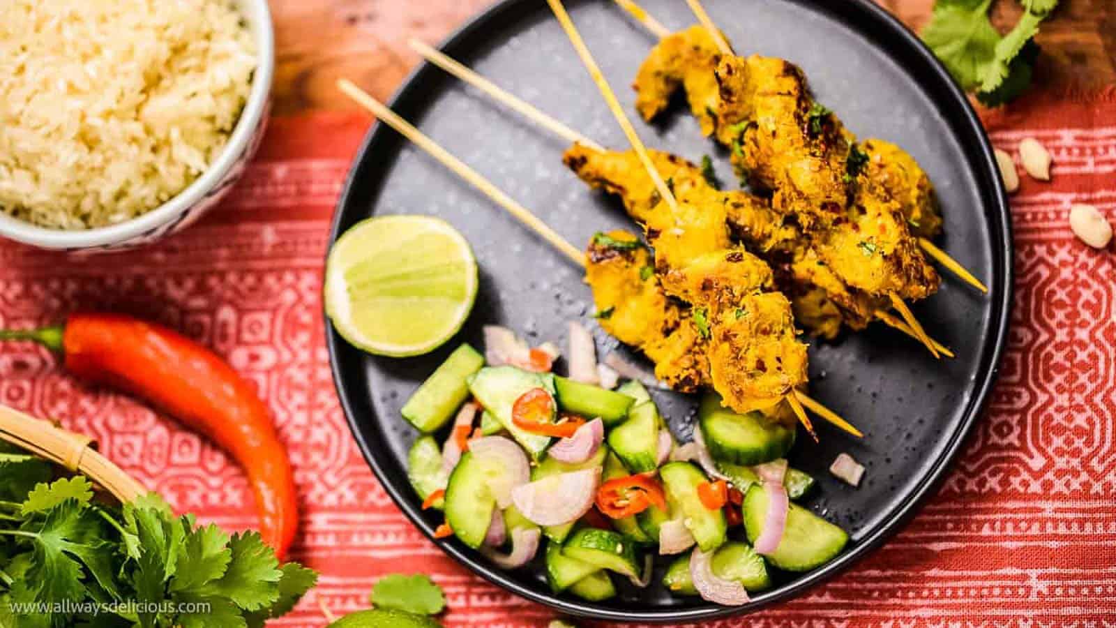 Thai chicken skewers and rice served with cucumbers, inspired by street foods.