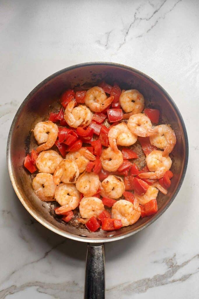 Red bell pepper and shrimp in a skillet.