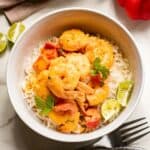 Overhead shot of Thai shrimp curry over steamed rice in a white bowl.