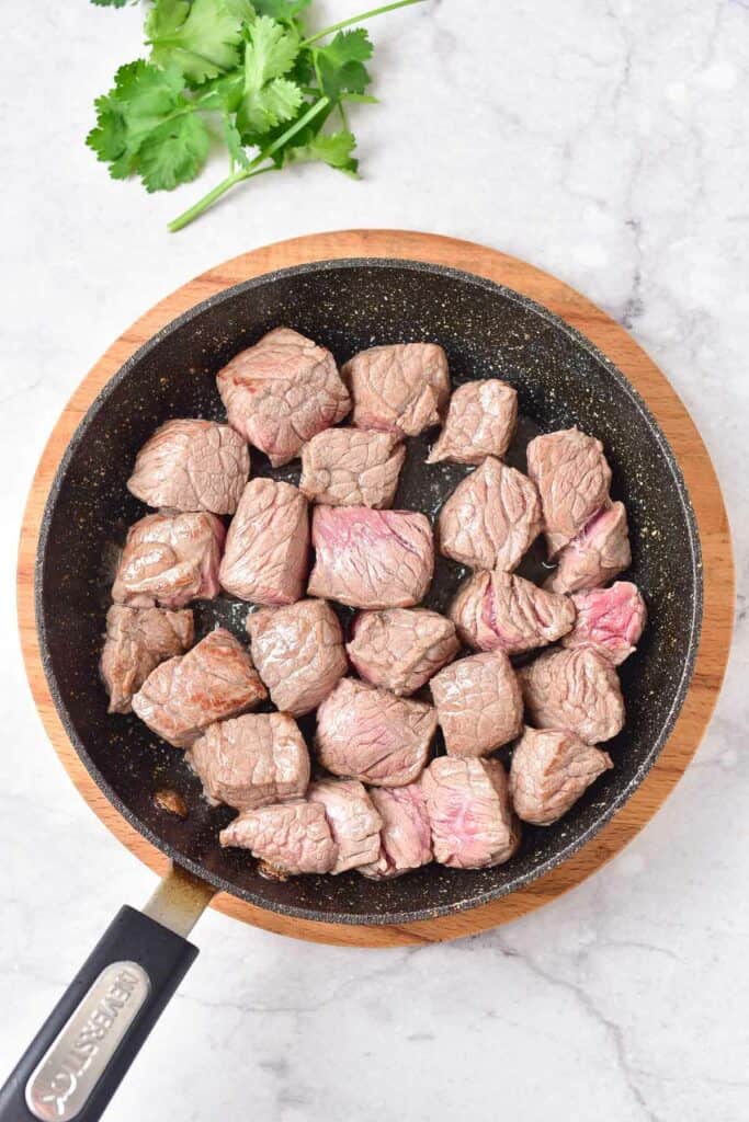 beef chunks in a skillet.