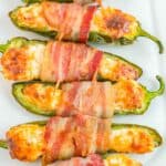 Bacon wrapped jalapenos on a white plate.