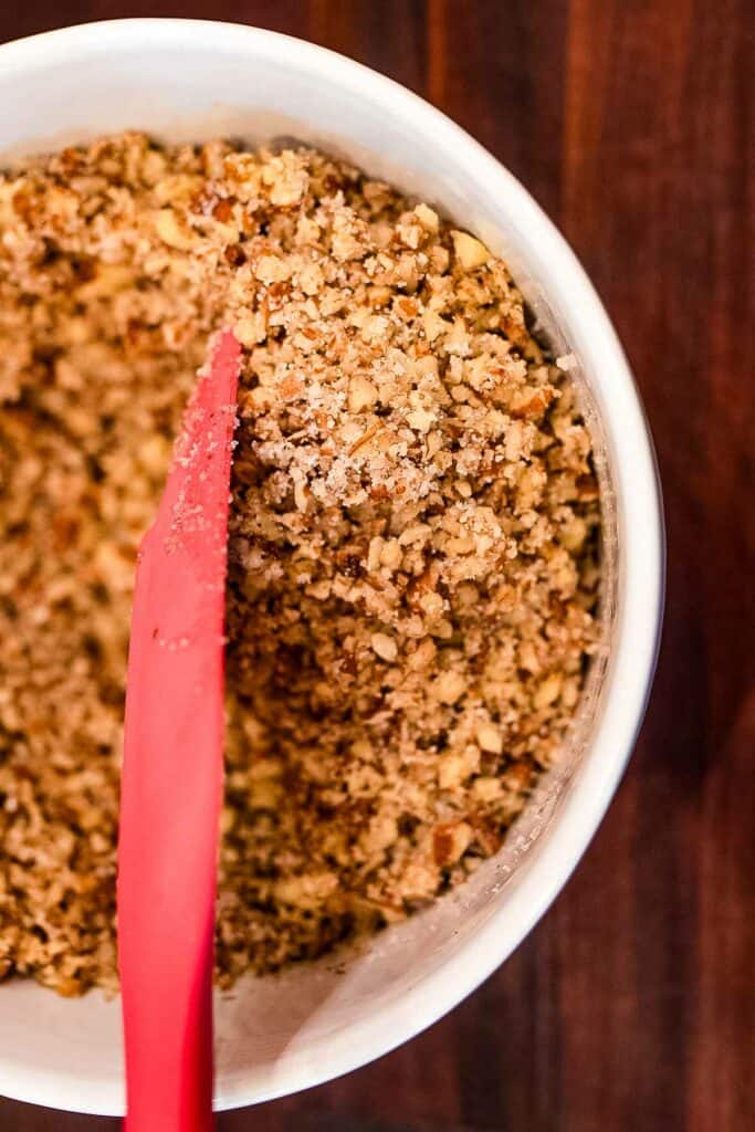 Granola in a bowl with a red spatula.