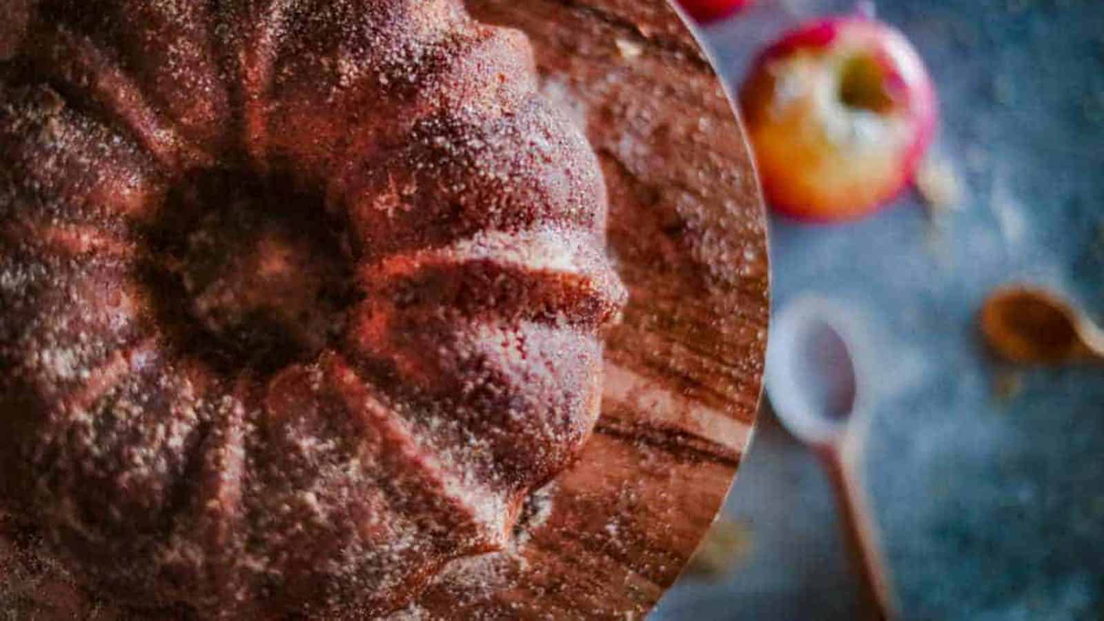Overhead shot of this apple bundt cake on a cake stand with apples in the background.
