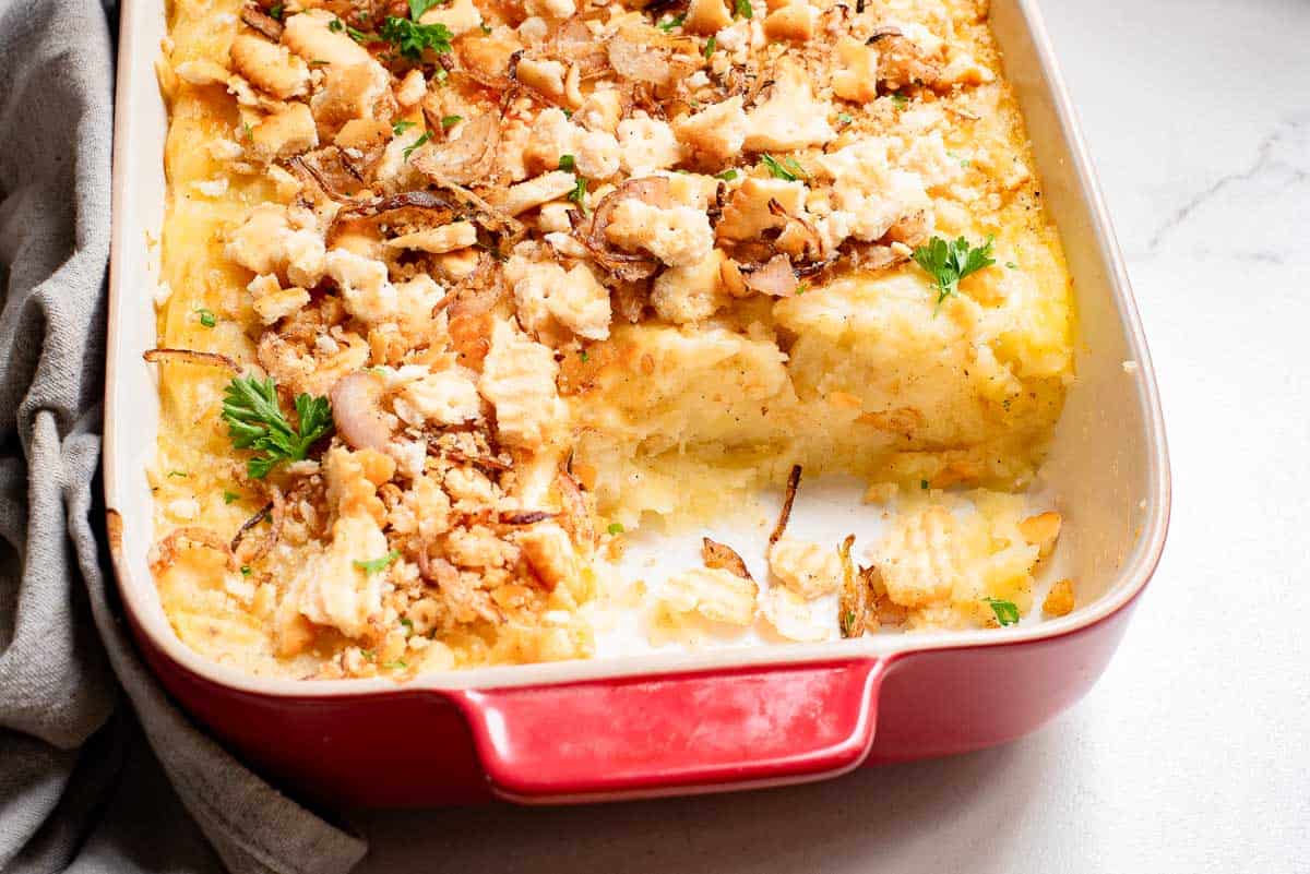 A casserole dish filled with mashed potatoes and cheese.