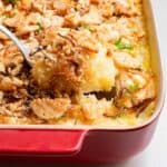 A casserole dish with a spoon in it.