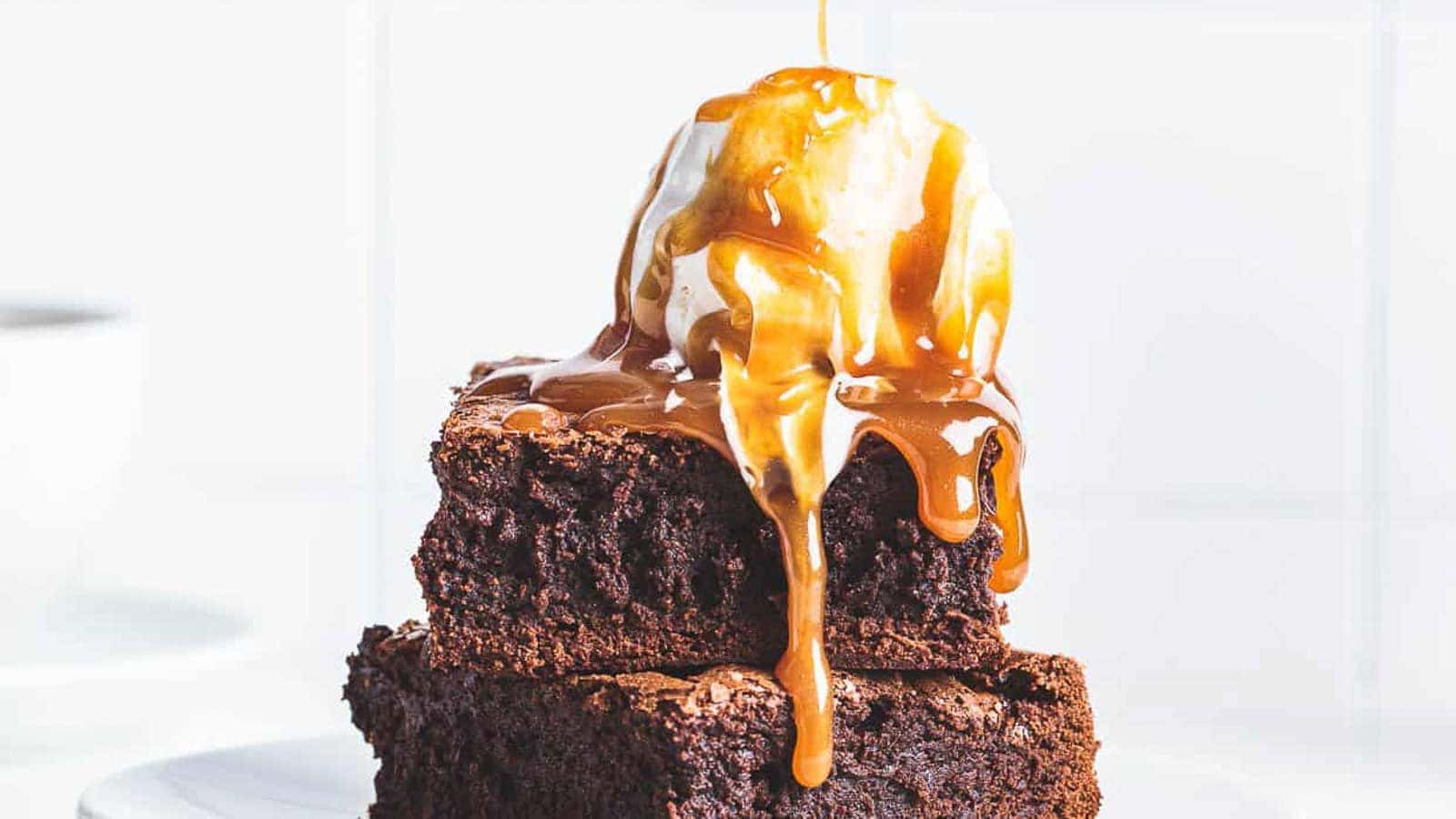 Brownies and ice cream with miso caramel being drizzled over the top.