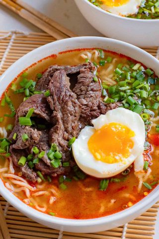 A bowl of Korean ramen with beef and an egg on top.