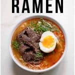 A bowl of Korean ramen with sliced beef, green onions, and a soft-boiled egg, labeled as "undeniably delicious.