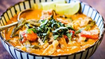 Drool-worthy Thai chicken curry in a bowl on a wooden table.