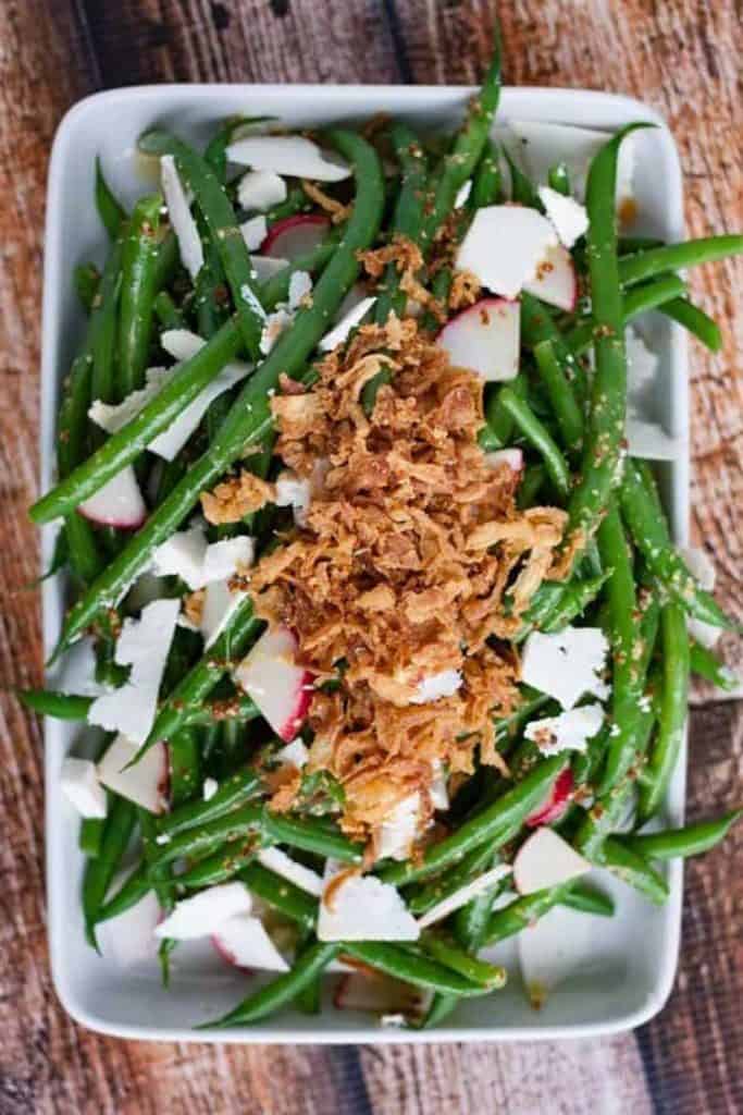 A dish of green bean salad with radishes, feta cheese, and crispy onions from our recipes collection.