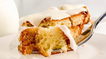 Honey bun cake with white frosting on a fork.