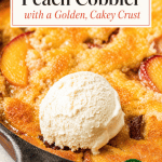 A cast iron skillet filled with peach cobbler topped with a scoop of vanilla ice cream, showing baked peaches and a golden crust.